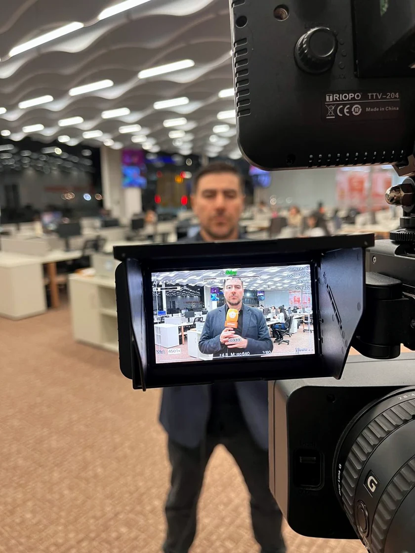 Fernando Zanuzo na redação, enquadrado pela câmera de TV durante a gravação